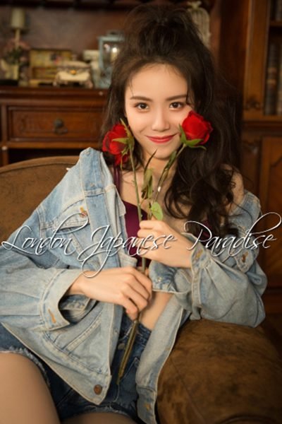 Ida Cute Asian London Escort in denim jacket holding a red rose