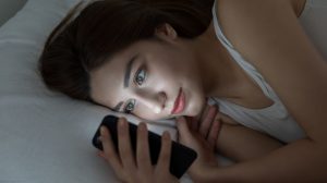 Girl texting in bed