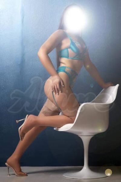 shapely Newcastle escort with her knee on chair