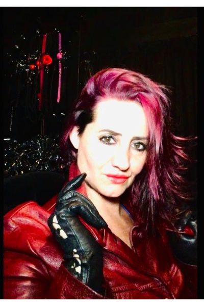 Lady Amber with red hair and wearing red leather