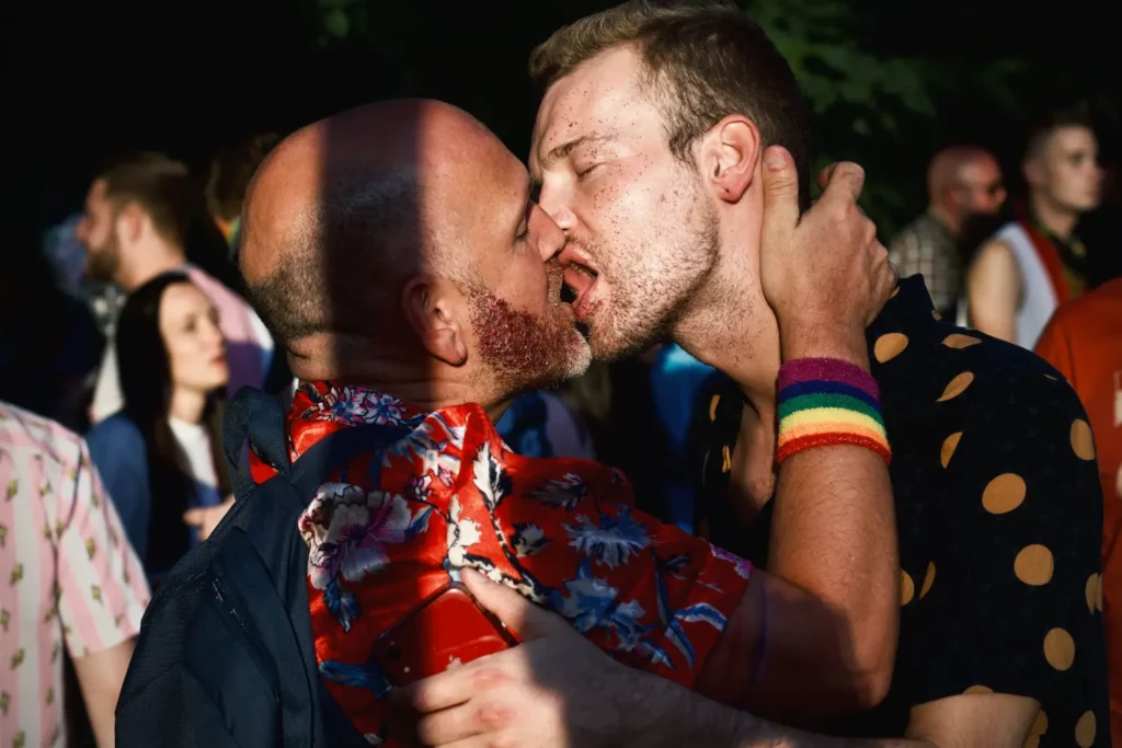 Two men kissing in public