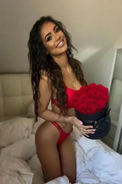 Sexy brunette escort holding red roses