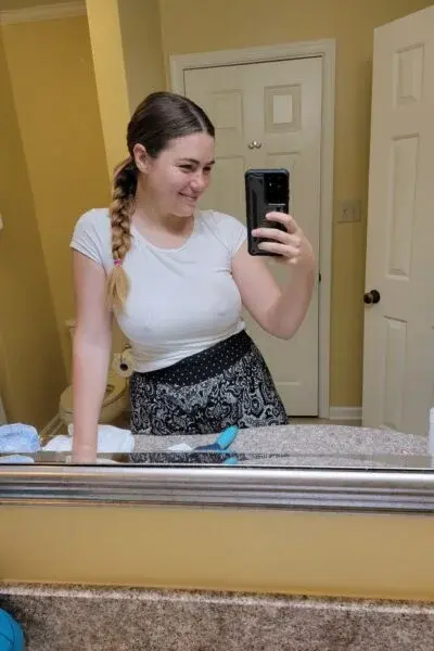 Busty escort takes a selfie in the bathroom mirror