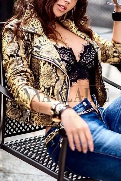 Busty brunette escort in snakeskin jacket